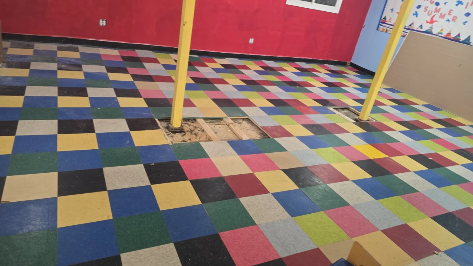 Multicolor tiled interior floor with an open section showing the subfloor